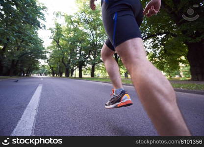 healthy athlete man jogging at morning on empty roat in the city