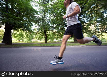 healthy athlete man jogging at morning on empty roat in the city