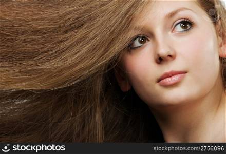 Healthy beautiful long hair closeup in motion created by wind. Portrait