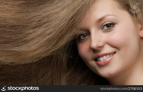 Healthy beautiful long hair closeup in motion created by wind. Portrait