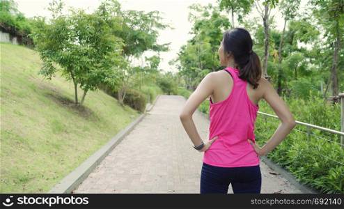 Healthy beautiful young Asian Athlete women in sports clothing legs warming and stretching her arms to ready for running on street in urban city park. Lifestyle active women exercise in city concept.