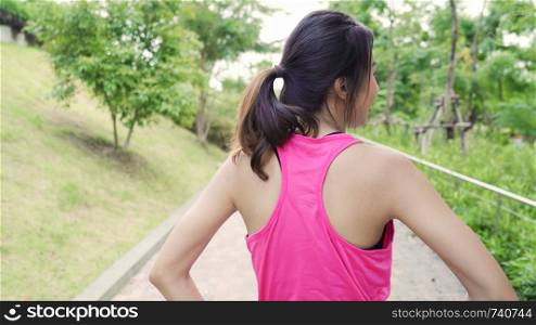 Healthy beautiful young Asian Athlete women in sports clothing legs warming and stretching her arms to ready for running on street in urban city park. Lifestyle active women exercise in city concept.