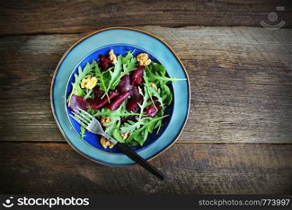Healthy Beet Salad with fresh sweet baby spinach, arugula, nuts on wooden background . Top view .. Healthy Beet Salad with fresh sweet baby spinach, arugula, nuts on wooden background . Top view