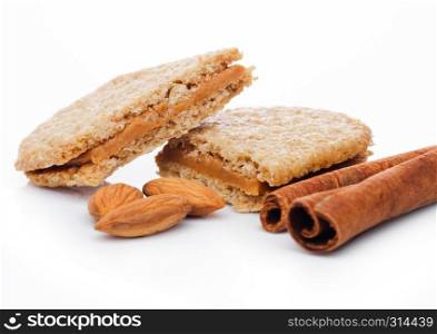 Healthy bio breakfast grain biscuits with almonds and cinnamon on white background
