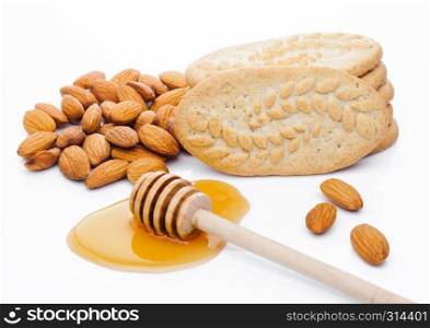 Healthy bio breakfast grain biscuits with honey and almonds on white background