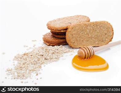 Healthy bio breakfast grain biscuits with honey and raw oat porridge on white background
