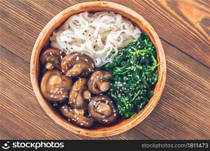 Healthy bowl with rice noodles, marinated shiitake and steamed spinach