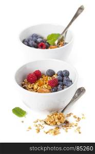 Healthy breakfast. Granola with fresh organic raspberries and blueberries on white background