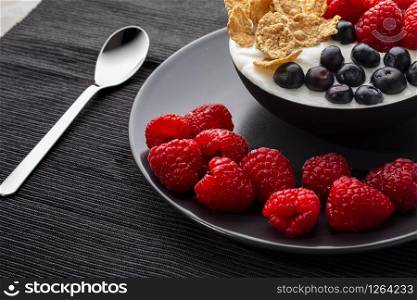 Healthy breakfast in bowl with yogurt and berries and cereals.