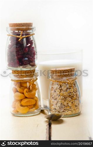 healthy breakfast ingredients milk oat cashew nuts dried cramberry craisinns