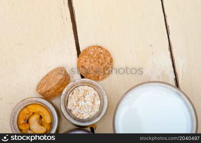 healthy breakfast ingredients milk oat cashew nuts dried cramberry craisinns