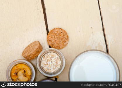 healthy breakfast ingredients milk oat cashew nuts dried cramberry craisinns