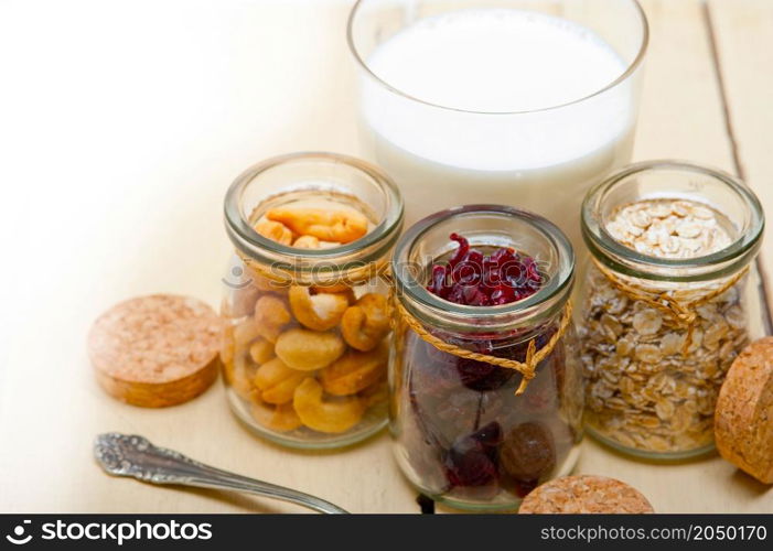 healthy breakfast ingredients milk oat cashew nuts dried cramberry craisinns