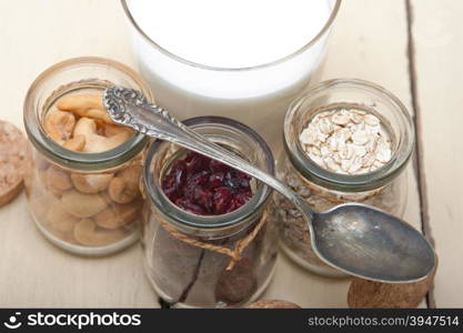 healthy breakfast ingredients milk oat cashew nuts dried cramberry craisinns