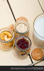 healthy breakfast ingredients milk oat cashew nuts dried cramberry craisinns