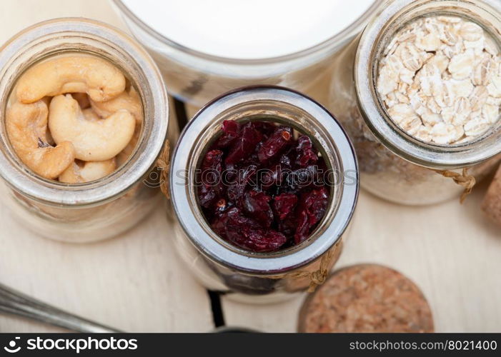 healthy breakfast ingredients milk oat cashew nuts dried cramberry craisinns