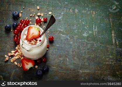 Healthy breakfast of muesli, berries with yogurt and seeds on dark background - Healthy food, Diet, Detox, Clean Eating or Vegetarian concept.