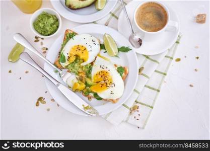 healthy breakfast or snack - sliced avocado and fried egg on toasted bread and cup of coffee.. healthy breakfast or snack - sliced avocado and fried egg on toasted bread and cup of coffee