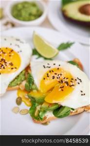 healthy breakfast or snack - sliced avocado and fried egg on toasted bread and cup of coffee.. healthy breakfast or snack - sliced avocado and fried egg on toasted bread and cup of coffee
