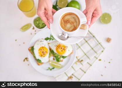 healthy breakfast or snack - sliced avocado and fried egg on toasted bread and cup of coffee.. healthy breakfast or snack - sliced avocado and fried egg on toasted bread and cup of coffee