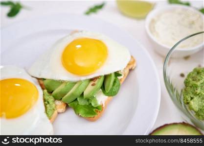 healthy breakfast or snack - sliced avocado and fried egg on toasted bread.. healthy breakfast or snack - sliced avocado and fried egg on toasted bread 