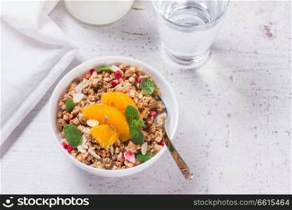 Healthy breakfast - plate of granola with orange slices, mint and seeds. Healthy breakfast with granola