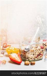 Healthy breakfast table with muesli in glass jar with berries and nuts , close up