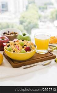healthy breakfast with cornflakes dried fruits apple juice glass table