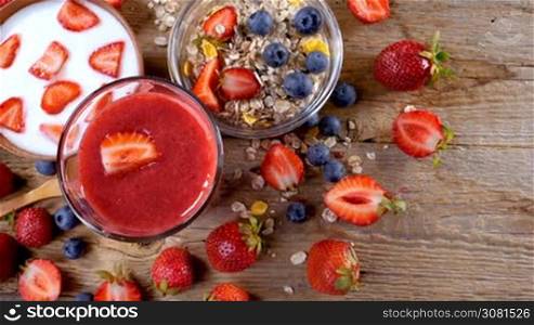 Healthy breakfast with strawberry smoothie, yogurt and cereals. Handheld movement.