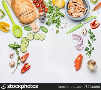 Healthy clean eating layout for lunch food and diet nutrition concept. Various fresh vegetables ingredients for salad with green cooking spoon and knife on white table background, top view, frame