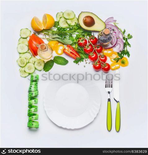 Healthy clean eating or diet food concept. Various salad vegetables with white plate , cutlery and green measuring tape on white background, top view, flat lay, frame.