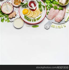 Healthy clean eating or sport nutrition concept. Chicken breast with fresh low calorie ingredients , herbs and spices on white background, top view, border. Weight loss food
