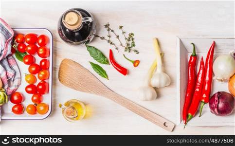 Healthy cooking with various fresh spices: olive oil, chili, onion, garlic and Bay leaves on white wooden background, top view