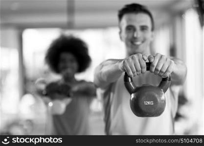 healthy couple workout with weights lifting dumbbels at crossfit gym african american woman with afro hairstyle