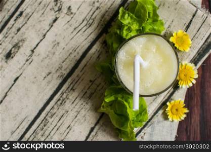 Healthy Custard Apple smoothie in a glass, on a rustic white wood background