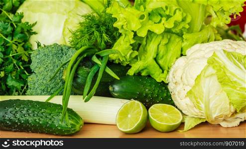 Healthy diet and meal ingredients concept. Many green vegetables on kitchen table. Many green vegetables on kitchen table