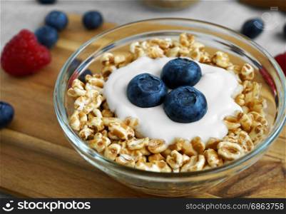 Healthy diet breakfast with a bowl of yogurt, spelt flakes and fresh blueberries fruit.