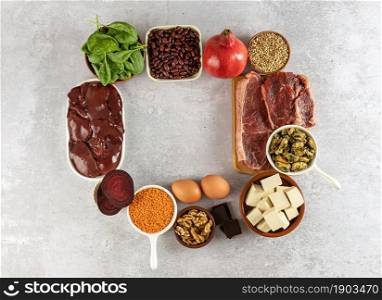 Healthy diet concept, foods high in Iron, including eggs, nuts, spinach, beans, tofu, liver, beef, beetroot, mussels, and dark chocolate.