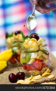 healthy diet. girl hand with a spoon and oatmeal with berries and fruits, measurer
