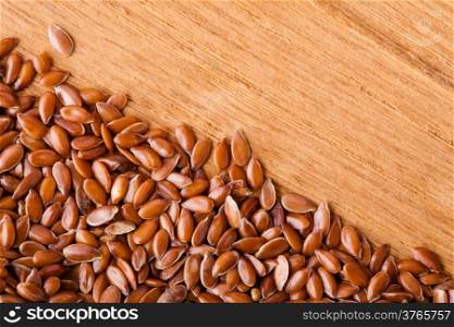 Healthy diet organic nutrition. Brown raw flax seeds linseed border frame on wooden table background