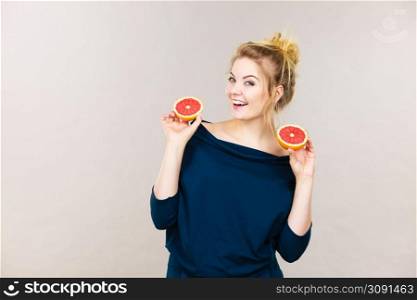 Healthy diet, refreshing food full of vitamins. Happy woman holding sweet delicious citrus fruit, red grapefruit.. Happy smiling woman holding red grapefruit