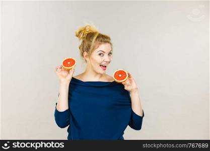 Healthy diet, refreshing food full of vitamins. Happy woman holding sweet delicious citrus fruit, red grapefruit.. Happy smiling woman holding red grapefruit