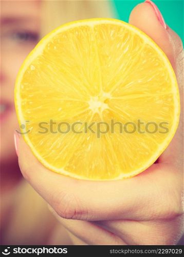 Healthy diet, refreshing food full of vitamins. Woman holding sweet delicious citrus fruit, lemon on orange.. Woman holding fruit lemon or orange