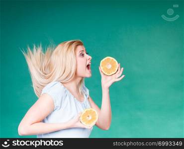 Healthy diet, refreshing food full of vitamins. Woman with open mouth holding sweet delicious citrus fruit, orange grapefruit, she wants to take bite.. Woman with open mouth holding grapefruit