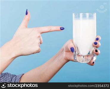 Healthy drinks, good nutrition, dairy products concept. Woman hand holding glass of milk. Woman hand holding glass of milk