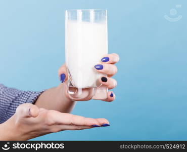 Healthy drinks, good nutrition, dairy products concept. Woman hand holding glass of milk. Woman hand holding glass of milk