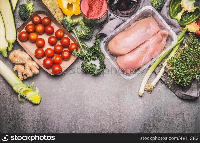 Healthy eating and cooking with chicken and various organic vegetables, preparation on gray concrete background, top view, border. Healthy food and Sports or diet nutrition concept