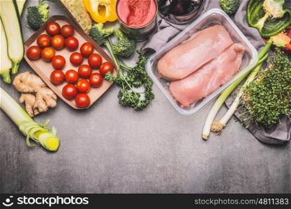 Healthy eating and cooking with chicken and various organic vegetables, preparation on gray concrete background, top view, border. Healthy food and Sports or diet nutrition concept