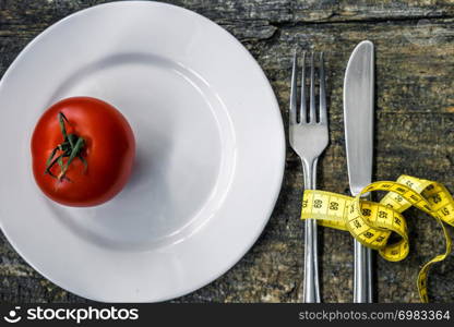 Healthy eating and Diet concept. Plate with fresh tomato and measurement on wooden table.