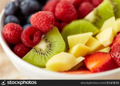 healthy eating and food concept - close up of fruits and berries in bowl. close up of fruits and berries in bowl